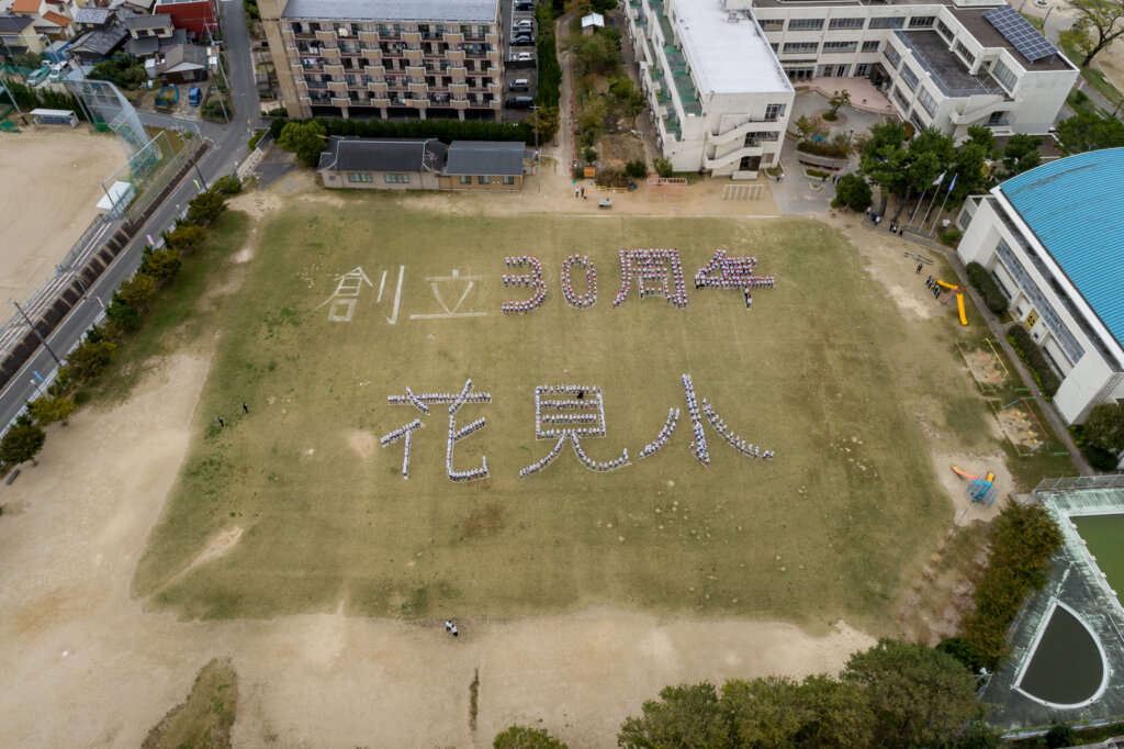 花見小学校のグラウンドに整列した人文字のドローン撮影