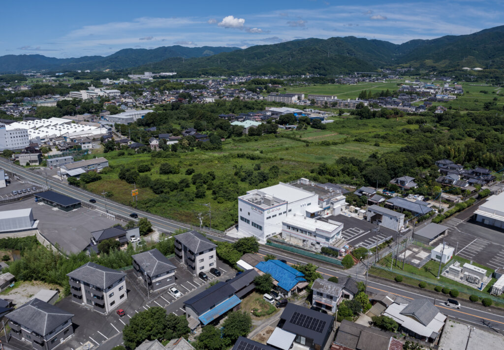 脊振山系を背景に収めたアートキャンディ佐賀工場のドローン空撮写真